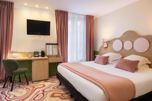 a hotel room with a bed and a desk and a television at Best Western Hotel Lakmi Nice in Nice