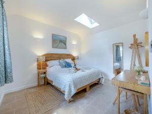 a bedroom with a bed and a table in it at Dunnock - Uk50146 in Faversham
