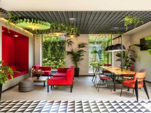 a restaurant with red chairs and a table at ibis Bucharest Politehnica in Bucharest