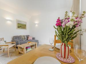 a living room with a table with a vase of flowers at Linnet - Uk50154 in Faversham