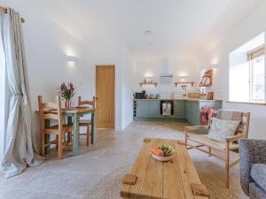 a living room with a table and a kitchen at Linnet - Uk50154 in Faversham