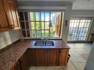 a kitchen with a sink and a view of a balcony at Departamento Microcentro San Rafael in San Rafael +8 photos