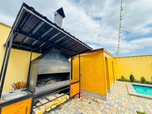 an outdoor kitchen with a grill and a swimming pool at Miracle View Dilijan in Dilijan +48 photos