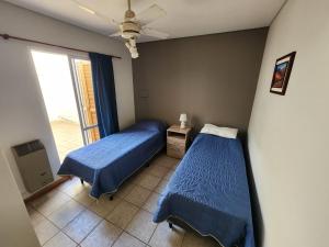 a bedroom with two beds and a window at Departamento Microcentro San Rafael in San Rafael
