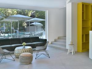 a living room with a couch and chairs and tables at ibis Styles Golden Sands Roomer Hotel in Golden Sands