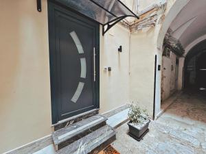 a large black door on a building with a potted plant at Abbate Apartments MIRI in Palermo