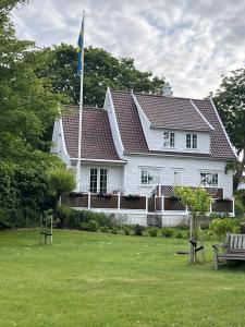 a white house with a flag and a bench at Eldhuset in Stavanger