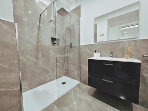 a bathroom with a glass shower and a sink at Abbate Apartments MIRI in Palermo +33 photos