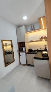 a small kitchen with a sink and a refrigerator at Residencial Ibiapaba FLAT 31 - com piscina e ótima localização in Camocim