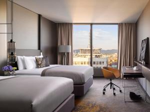 a hotel room with two beds and a desk at InterContinental - Ljubljana by IHG in Ljubljana