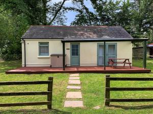 a small house with a porch and a fence at Beachside in Llanstephan +3 photos