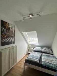 a white bedroom with a bed and a window at Ferienhaus Talblick in Kelberg