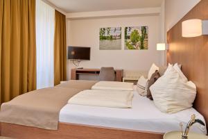 ein Hotelzimmer mit Bett und Schreibtisch in der Unterkunft Stadthotel Schärding in Schärding + 13 Fotos