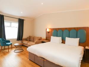 a bedroom with a large bed and a couch at Hedgehog Lodge in Chorley