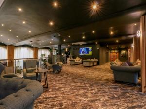 a lobby with couches and a tv in a building at Hedgehog Lodge in Chorley