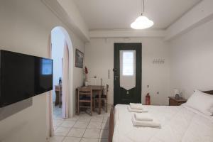 a bedroom with a bed and a flat screen tv at Gorgones, sea-front, great view in Kardamyli