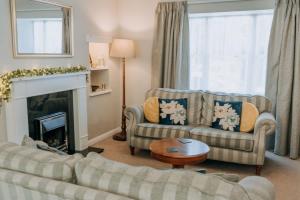 a living room with two couches and a fireplace at Charming St Davids Cottage with Cathedral Views in St. Davids