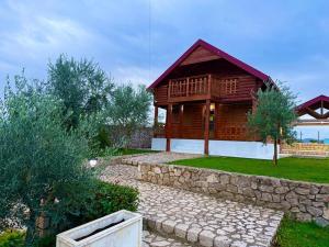 a log cabin with a stone walkway in front of it at Cosy Cottage with Private Pool - Andrej in Danilovgrad