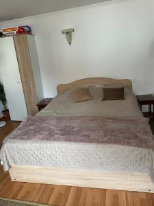 a large bed in a bedroom with wooden floors at Viki house in Hurez