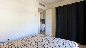 a bedroom with a bed with a black curtain at Virginia N 202 2P4 in Grasse +2 photos