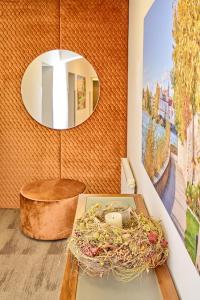 ein Zimmer mit einem Tisch mit einem Nestchen und einem Spiegel in der Unterkunft Stadthotel Schärding in Schärding