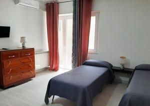 a bedroom with a bed and a dresser and a window at Al Palmento in Galati Mamertino