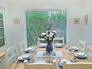 a dining room with a table with a vase of flowers at Riverside in Wimblington