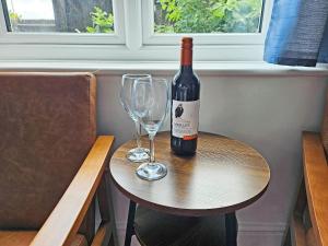 a bottle of wine and two glasses on a table at Riverside in Wimblington