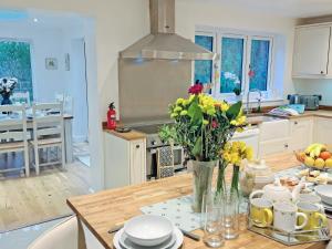 a kitchen with a table with flowers on it at Riverside in Wimblington