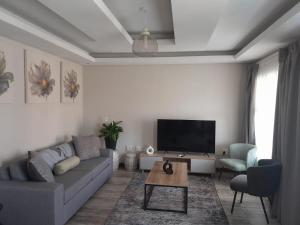 a living room with a couch and a flat screen tv at Magnolia Hotel in Middelburg