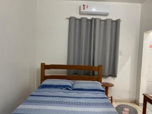 a bed in a room with a window with a curtain at Hotel Maria in Marabá +17 photos