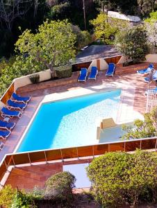 an overhead view of a swimming pool with blue lounge chairs and a pool at Résidence "Le Golfe Bleu" in Roquebrune-Cap-Martin