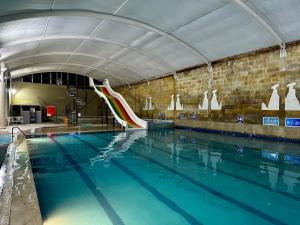 a swimming pool with a water slide in a building at Divaisib Termal Resort Hotel & Spa in Kozaklı