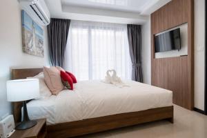 a bedroom with a white bed with a window at KAI Condo 1BR Pool View NBC Nai Harn in Rawai Beach