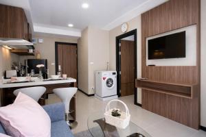 a living room with a desk and a tv in a room at KAI Condo 1BR Pool View NBC Nai Harn in Rawai Beach