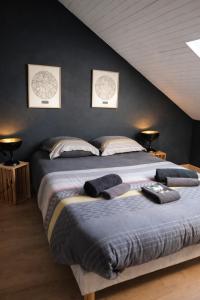 a large bed in a bedroom with two pictures on the wall at Le Petit Loft Vosgien -Escapade nature & cosy in Cornimont
