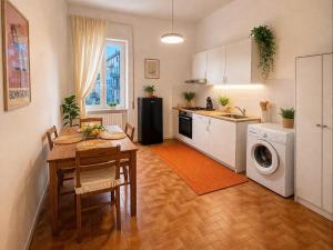 a kitchen with a table and a kitchen with a washing machine at ADAapartmenthousesalerno in Salerno