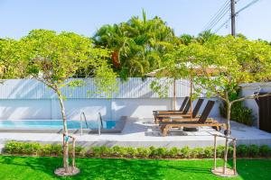 a pool with two chairs and trees in a yard at Chaba Pool Villa Khao Lak in Khao Lak