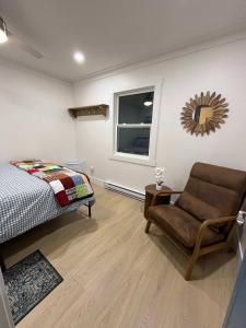 ein Schlafzimmer mit einem Bett, einem Stuhl und einem Fenster in der Unterkunft Durrell's Nook in Twillingate