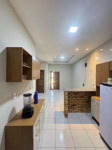 a large kitchen with a counter and a counter top at Casa em Tibau in Tibau