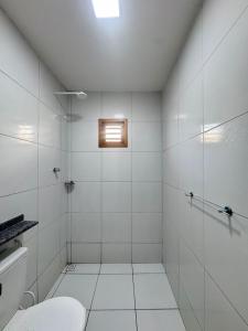 a white bathroom with a toilet and a window at Casa em Tibau in Tibau +26 photos