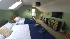 a bedroom with two beds and a flat screen tv at Brady Accommodation in Monaghan