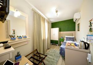 ein Schlafzimmer mit einem Bett und einer grünen Wand in der Unterkunft Dions hotel in Seferihisar