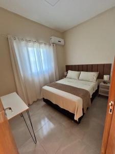 a bedroom with a large bed and a window at Casa, Delfinópolis - Serra da Canastra, MG in Delfinópolis