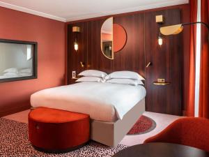 a bedroom with a large bed and a mirror at Nest Hotel Paris la Défense - MGallery Collection in Puteaux +72 photos