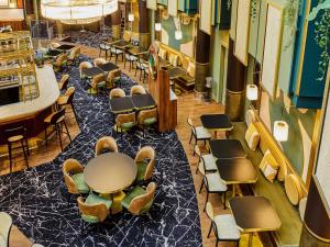 a dining room with a table and chairs in a building at Nest Hotel Paris la Défense - MGallery Collection in Puteaux