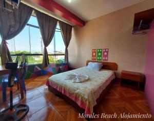 a bedroom with a bed and a large window at Alojamiento Morales Beach in Morales