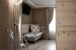 a small bedroom with a bed and a window at Hotel Orso Grigio in Cavalese