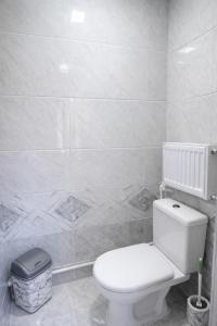 a bathroom with a toilet and a tiled wall at Sole Family Guesthouse in Samarkand +31 photos