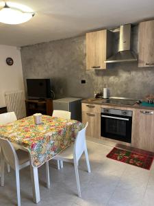 a kitchen with a table with chairs and a kitchen with a stove at Casa Maggini in Ancona